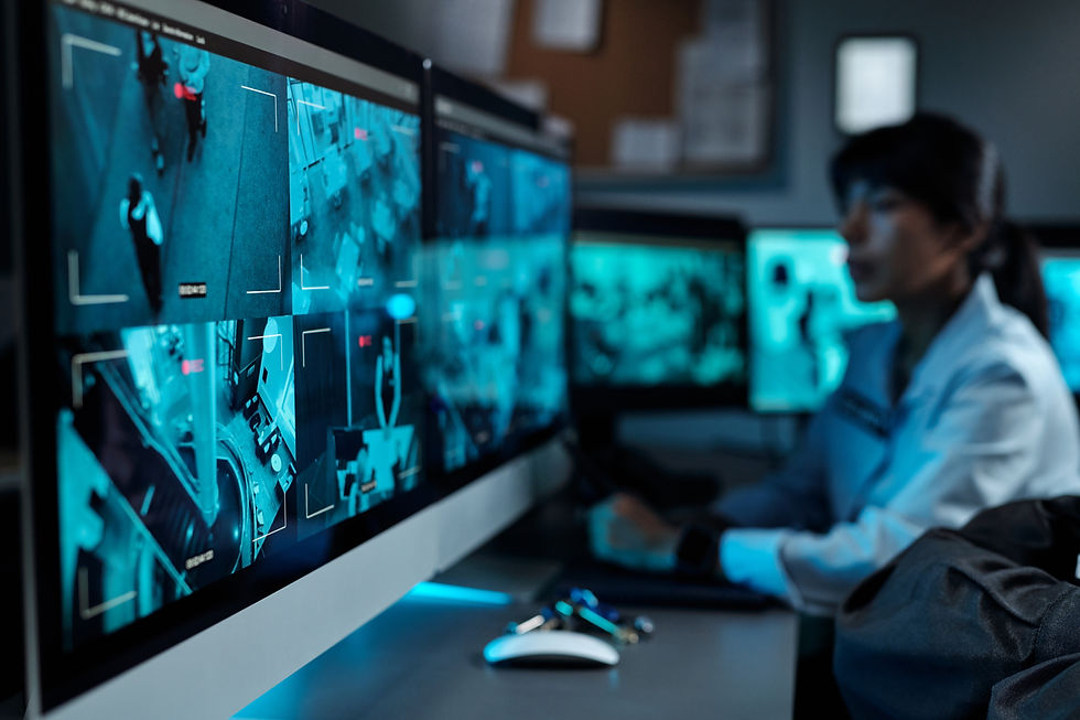Kobieta w białej koszuli obserwuje na monitorach niebiesko podświetlony system monitoringu z obrazami CCTV w biurze.